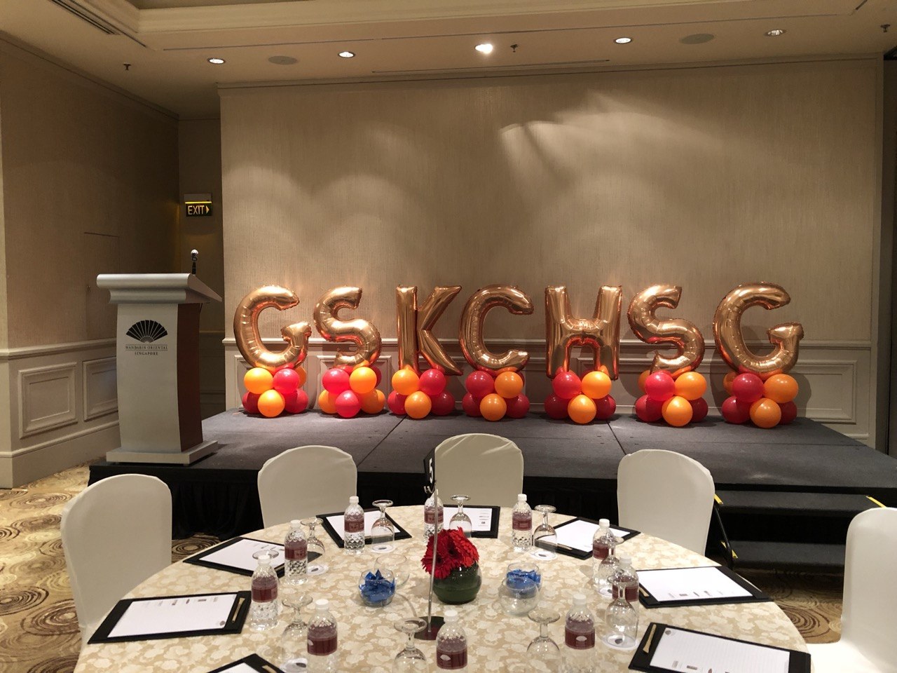 Gold balloon letters on a corporate stage